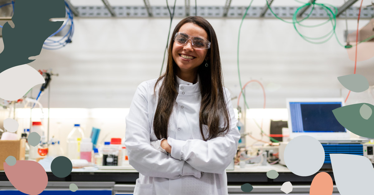 image of a smiling woman wearing a lab coat standing in a laboratory
